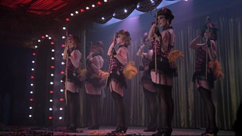 Movie still from “Cabaret” (1972), directed by Bob Fosse – A group of burlesque dancers performing on a stage; Wide shot, Low angle