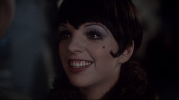 Movie still from “Cabaret” (1972), directed by Bob Fosse – A person wearing makeup; Close Up shot, Over the shoulder angle