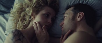 Movie still from “Café de Flore” (2011), directed by Jean-Marc Vallée – A man and a woman laying in a bed together; Close Up shot, Overhead angle