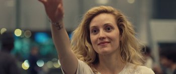 Movie still from “Café de Flore” (2011), directed by Jean-Marc Vallée – A beautiful woman with long blonde hair raising her hand; Close Up shot, Over the shoulder angle