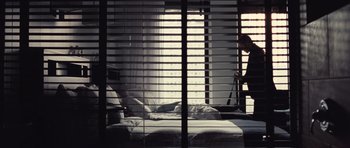 Movie still from “Café de Flore” (2011), directed by Jean-Marc Vallée – A person is standing in a room with a bed; Wide shot, Low angle