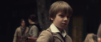 Movie still from “Café de Flore” (2011), directed by Jean-Marc Vallée – A young boy in a suit and a tie; Close Up shot, Over the shoulder angle