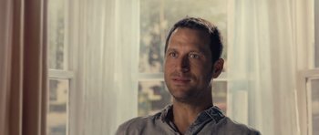 Movie still from “Café de Flore” (2011), directed by Jean-Marc Vallée – A person wearing a gray shirt near a window; Close Up shot, Over the shoulder angle