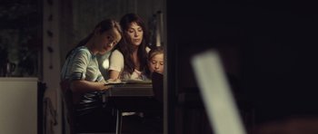 Movie still from “Café de Flore” (2011), directed by Jean-Marc Vallée – A woman and two children sitting at a table; Medium shot, Over the shoulder angle