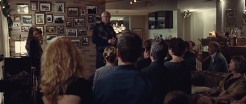 Movie still from “Café de Flore” (2011), directed by Jean-Marc Vallée – An older man standing in front of a group of people; Wide shot, Over the shoulder angle