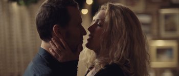 Movie still from “Café de Flore” (2011), directed by Jean-Marc Vallée – A man and a woman kissing in front of lights; Close Up shot, Low angle