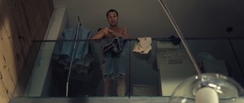 Movie still from “Café de Flore” (2011), directed by Jean-Marc Vallée – A man is holding a towel on a balcony; Medium shot, High angle