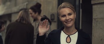 Movie still from “Café de Flore” (2011), directed by Jean-Marc Vallée – A woman waving at the camera while standing in front of other people; Close Up shot, Over the shoulder angle
