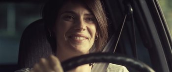 Movie still from “Café de Flore” (2011), directed by Jean-Marc Vallée – A person in a car holding an umbrella; Close Up shot, Over the shoulder angle