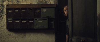 Movie still from “Café de Flore” (2011), directed by Jean-Marc Vallée – A man standing next to a bunch of drawers; Medium shot, Low angle