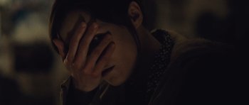 Movie still from “Café de Flore” (2011), directed by Jean-Marc Vallée – A person holding their hands up to their face; Close Up shot, Over the shoulder angle