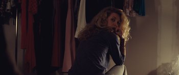 Movie still from “Café de Flore” (2011), directed by Jean-Marc Vallée – A woman sitting on a couch in front of a mirror; Medium shot, Over the shoulder angle