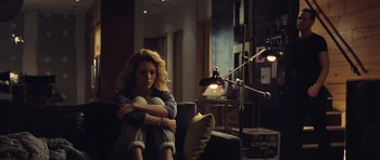 Movie still from “Café de Flore” (2011), directed by Jean-Marc Vallée – A woman sitting on a chair in a living room; Medium shot, High angle