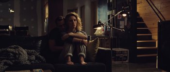 Movie still from “Café de Flore” (2011), directed by Jean-Marc Vallée – A woman sitting on top of a black couch next to a man; Medium shot, High angle