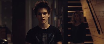 Movie still from “Café de Flore” (2011), directed by Jean-Marc Vallée – A young man with spiky hair wearing a t - shirt; Medium shot, Over the shoulder angle