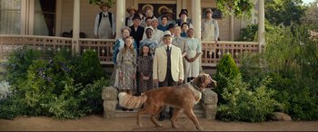 Movie still from “The Call of the Wild” (2020), directed by Chris Sanders – A group of people and a dog on a porch; Wide shot, Low angle