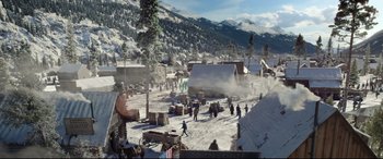Movie still from “The Call of the Wild” (2020), directed by Chris Sanders – A group of people walking in the snow near some buildings; Extreme Wide shot, High angle