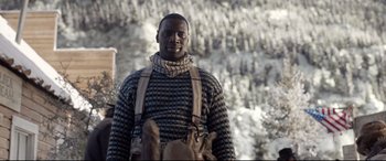 Movie still from “The Call of the Wild” (2020), directed by Chris Sanders – A man standing in front of a snow covered forest; Medium shot, Low angle