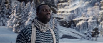 Movie still from “The Call of the Wild” (2020), directed by Chris Sanders – A man wearing a scarf standing in front of a snowy mountain; Close Up shot, Low angle