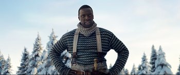 Movie still from “The Call of the Wild” (2020), directed by Chris Sanders – A man in a sweater and suspenders standing in the snow; Medium shot, Low angle