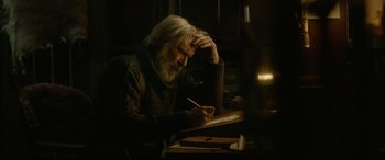 Movie still from “The Call of the Wild” (2020), directed by Chris Sanders – An older man writing on a piece of paper; Medium shot, Low angle