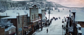 Movie still from “The Call of the Wild” (2020), directed by Chris Sanders – A group of people walking on a snow covered street; Extreme Wide shot, High angle