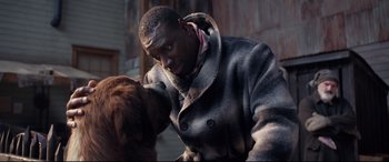 Movie still from “The Call of the Wild” (2020), directed by Chris Sanders – A man in a gray coat petting a brown dog; Close Up shot, Over the shoulder angle