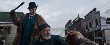 Movie still from “The Call of the Wild” (2020), directed by Chris Sanders – A man in a hat and a fur coat next to another man in a hat and a fur coat next to a dog; Medium shot, Over the shoulder angle