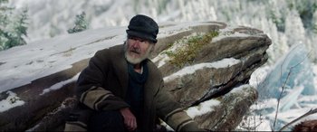 Movie still from “The Call of the Wild” (2020), directed by Chris Sanders – An old man sitting on the ground in the snow; Medium shot, Low angle