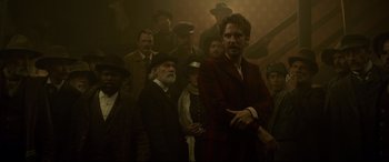 Movie still from “The Call of the Wild” (2020), directed by Chris Sanders – A group of men standing next to each other in a room; Medium shot, Low angle