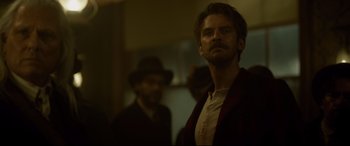 Movie still from “The Call of the Wild” (2020), directed by Chris Sanders – A man with a beard and a hat standing in front of another man; Medium shot, Over the shoulder angle