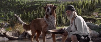 Movie still from “The Call of the Wild” (2020), directed by Chris Sanders – An old man holding a plate with a dog on the ground; Wide shot, Low angle