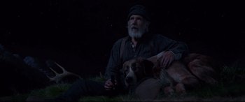 Movie still from “The Call of the Wild” (2020), directed by Chris Sanders – An old man sitting on the ground with a dog; Medium shot, Low angle