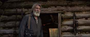 Movie still from “The Call of the Wild” (2020), directed by Chris Sanders – An old man with a beard standing in front of a log cabin; Medium shot, Low angle