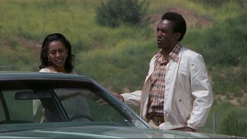 Movie still from “California Suite” (1978), directed by Herbert Ross – A man and a woman standing in front of a car; Medium shot, Low angle