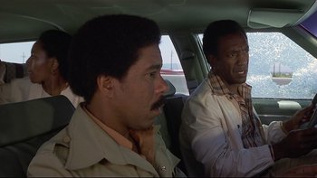 Movie still from “California Suite” (1978), directed by Herbert Ross – Two men sitting in the back seat of a car; Medium shot, Over the shoulder angle