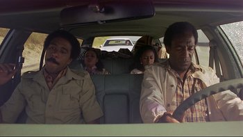 Movie still from “California Suite” (1978), directed by Herbert Ross – A group of people sitting in the back of a car; Medium shot, High angle