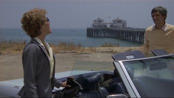 Movie still from “California Suite” (1978), directed by Herbert Ross – A woman standing next to a car near the ocean; Wide shot, Low angle