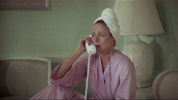 Movie still from “California Suite” (1978), directed by Herbert Ross – A woman with a towel wrapped around her head talking on a phone; Close Up shot, High angle