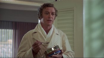 Movie still from “California Suite” (1978), directed by Herbert Ross – A man in a white robe holding a container of food; Medium shot, Over the shoulder angle