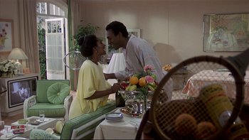 Movie still from “California Suite” (1978), directed by Herbert Ross – A man and a woman standing at a dining room table; Medium shot, Over the shoulder angle