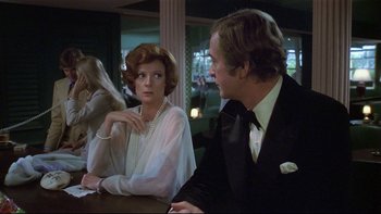 Movie still from “California Suite” (1978), directed by Herbert Ross – A woman sitting next to a man in a tuxedo; Medium shot, Over the shoulder angle