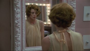 Movie still from “California Suite” (1978), directed by Herbert Ross – A woman looking at her reflection in a mirror; Medium shot, Over the shoulder angle