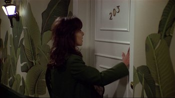 Movie still from “California Suite” (1978), directed by Herbert Ross – A woman standing in front of a white door; Medium shot, High angle