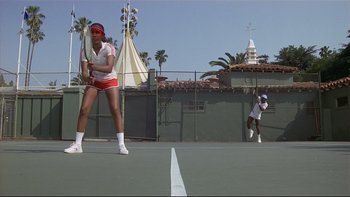 Movie still from “California Suite” (1978), directed by Herbert Ross – A woman holding a racquet on top of a tennis court; Wide shot, Low angle