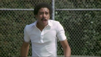 Movie still from “California Suite” (1978), directed by Herbert Ross – A man in a white shirt is playing tennis; Medium shot, Low angle
