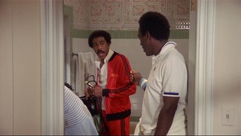 Movie still from “California Suite” (1978), directed by Herbert Ross – Two men are standing in a bathroom together; Medium shot, Over the shoulder angle