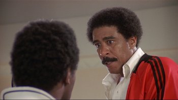 Movie still from “California Suite” (1978), directed by Herbert Ross – A man in a red jacket looking at himself in the mirror; Close Up shot, Low angle