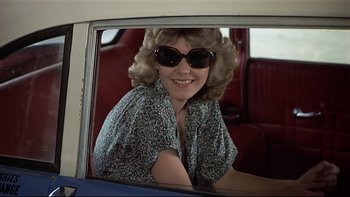 Movie still from “California Suite” (1978), directed by Herbert Ross – A woman sitting in the passenger seat of a car wearing sunglasses; Medium shot, Low angle