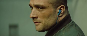 Movie still from “Calm with Horses” (2019), directed by Nick Rowland – A person wearing a blue ear piece; Close Up shot, Over the shoulder angle
